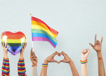 LGBTQ+ pride celebration with hand and crowd cheering