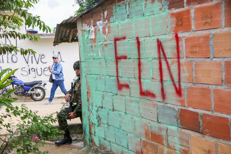 FILE PHOTO: A Colombian soldier leans on a wall while standing guard as members of a humanitarian caravan comprising senators and social organisations, meet with residents, to demand ceasefire and peace , after attacks by rebels from the leftist National Liberation Army (ELN), in the municipality of El Tarra, Colombia February 4, 2025. REUTERS/Carlos Eduardo Ramirez/File Photo